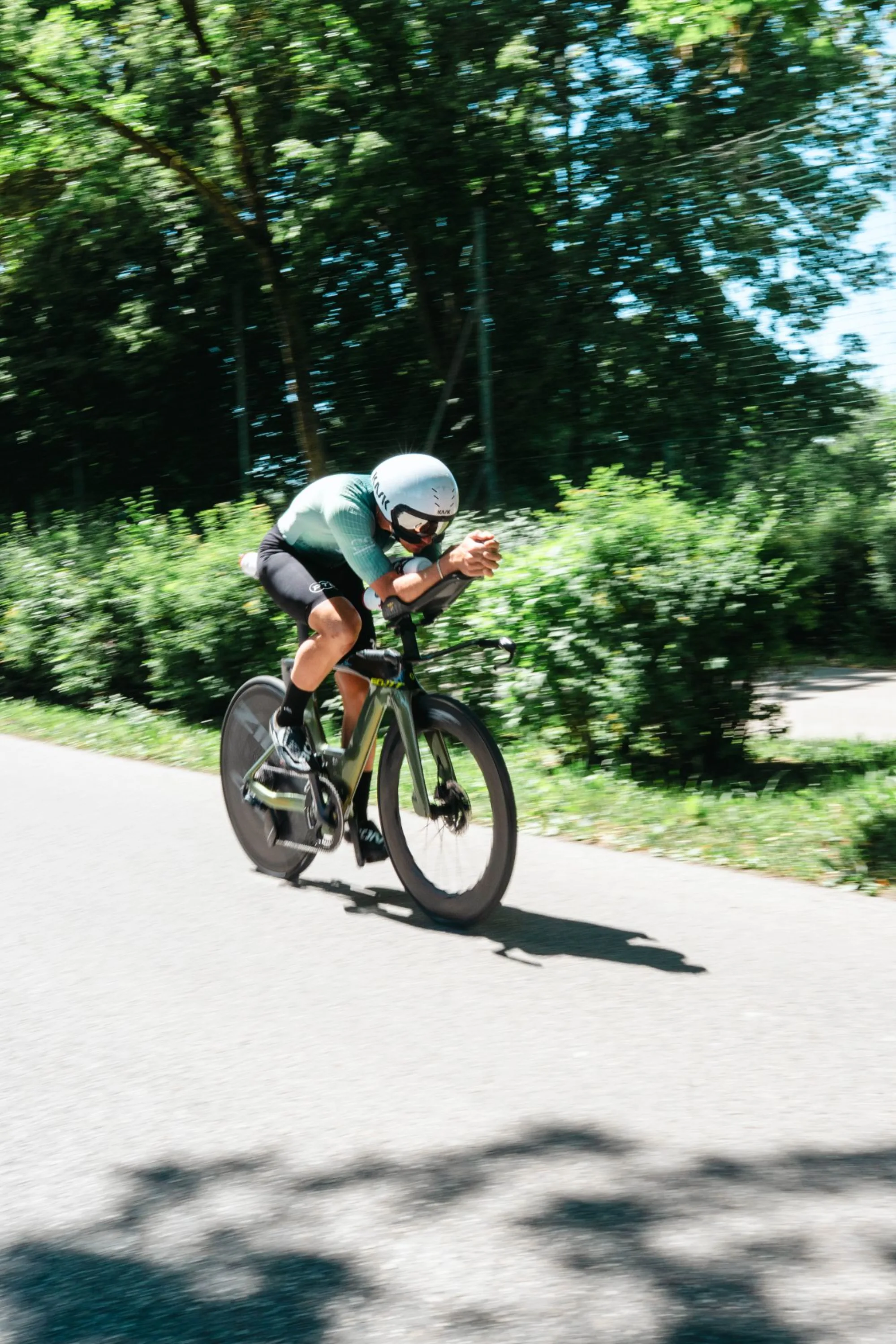 Athlet im mintfarbenen Custom Kit auf dem Zeitfahrrad